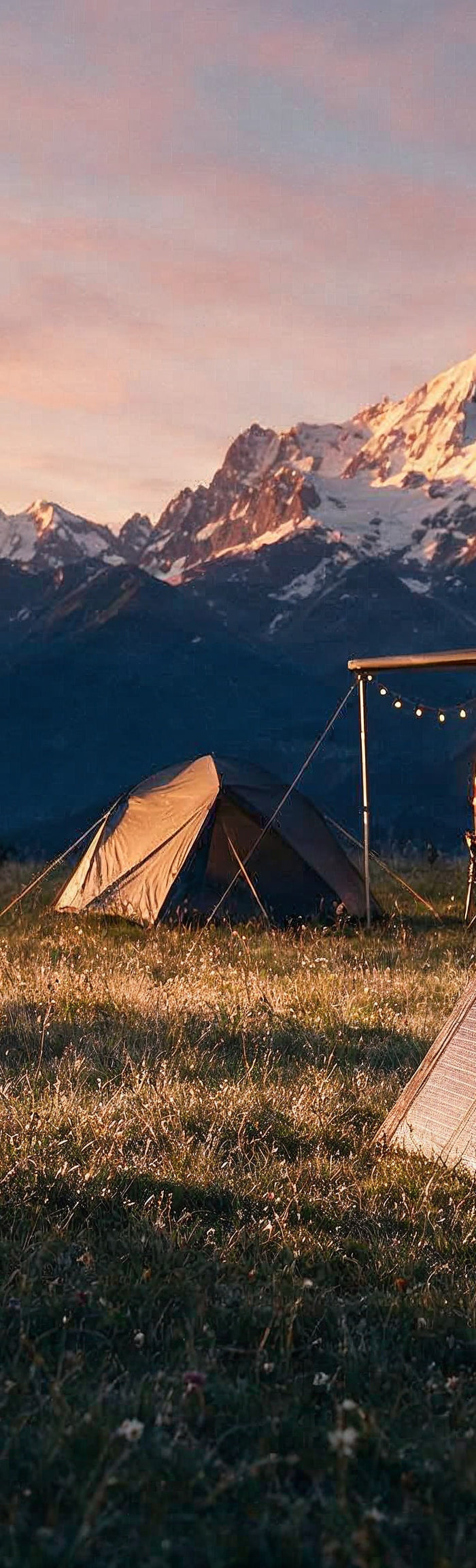 Camping in den Schweizer Alpen mit faltbarem Solarpanel und Powerstation bei Sonnenuntergang